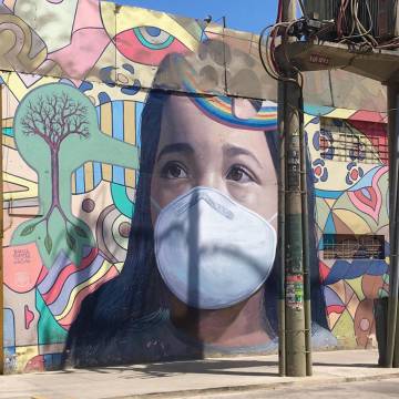 La boca resquebrajada de esta niña dibujada en las paredes de un mercado de Lima, en Perú, sirvió de excusa al artista Ricardo Cortez para incluir una mascarilla como forma de concienciar a los vecinos que cada día acuden a comprar a esta superficie.