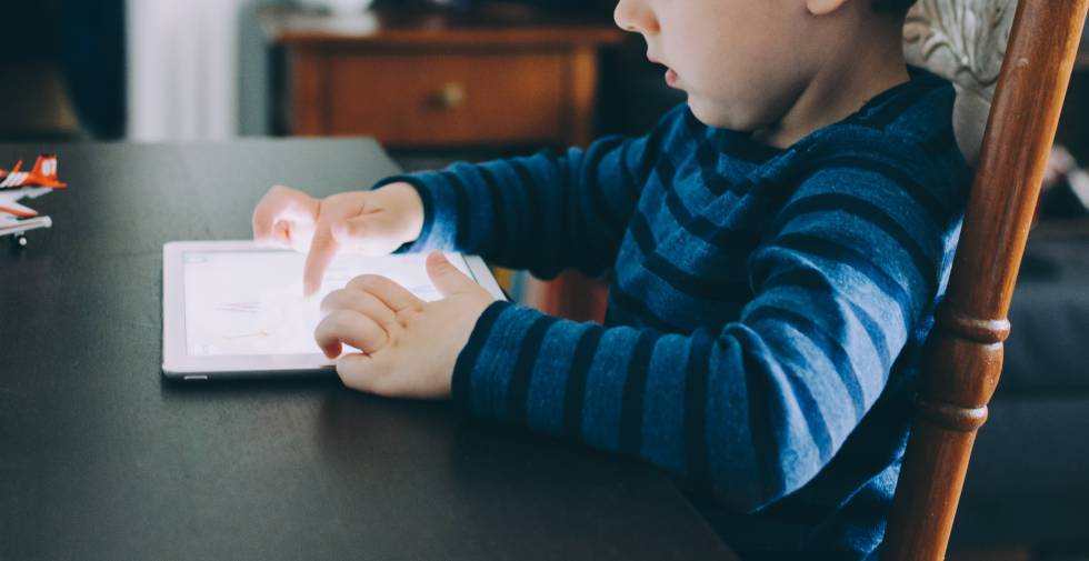 Un niÃ±o mira con atenciÃ³n su tableta. rn 