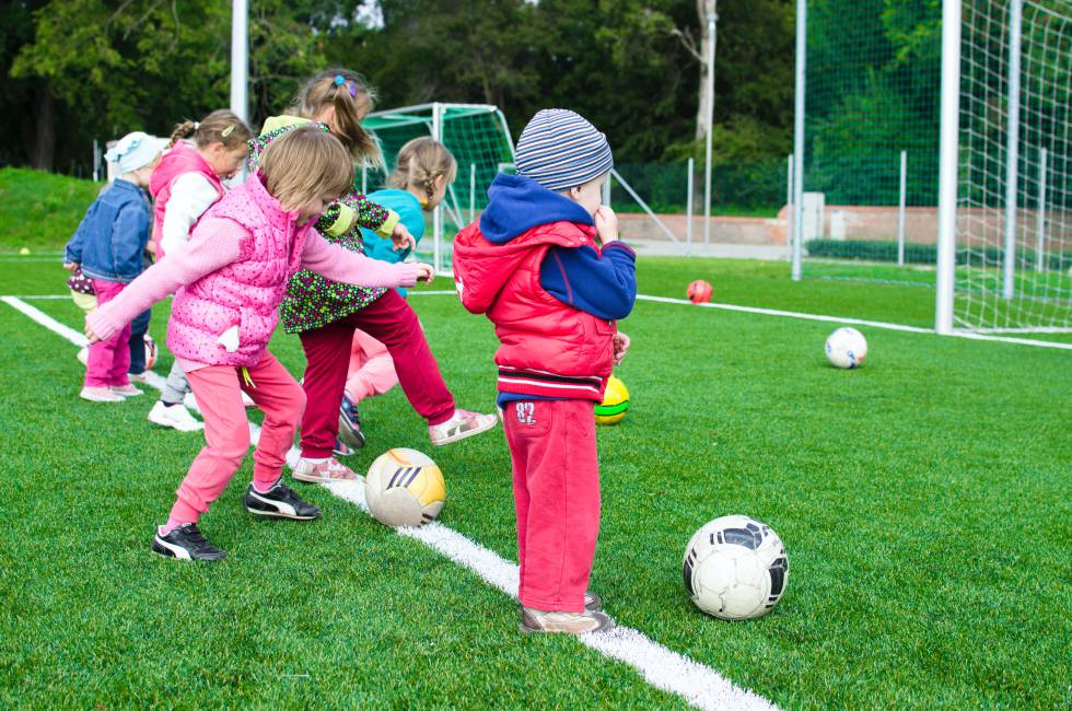 Varios niños juegan al fútbol. 