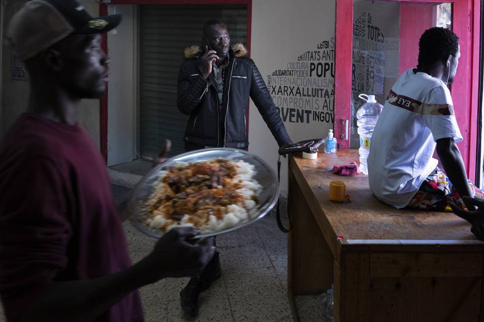Serigne Mamadou, en el centro de la imagen, en el interior de un local donde preparan comida para los temporeros que duermen en la calle en Lleida.