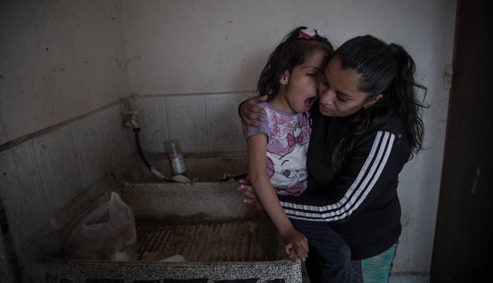 Valeria González y su hija Liz, que sufre discapacidad múltiple, en el lavadero donde se asean. Viven sin agua corriente en Ecatepec (México).