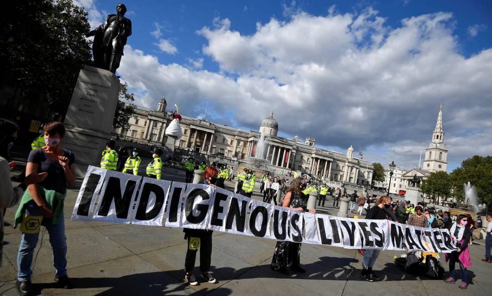 Unos activistas por el clima de la asociación Extinction Rebellion sostienen una pancarta con el lema 'Las vidas indígenas importan' durante una protesta para visibilizar la situación de los pueblos originarios en la Amazonia en la plaza Trafalgar de Londres, Reino Unido, el 5 de septiembre de 2020.