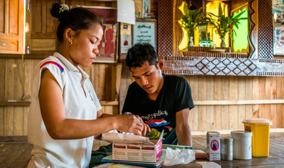 Naw Htay Htay Myint, trabajadora sanitaria de su comunidad, supervisa y registra a un voluntario para trabajar en la campaña contra la malaria en la aldea de Xwe Lay, estado de Kayin, Myanmar.