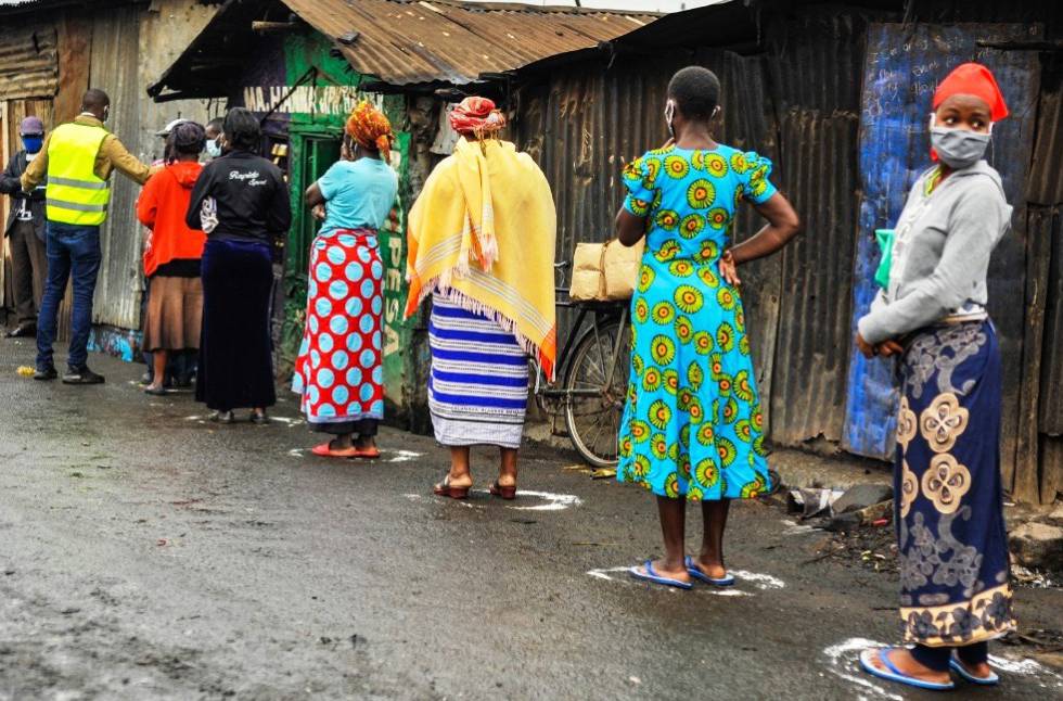 Several Mathare residents queue up to pick up food at neighborhood stores.