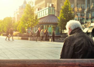 Un hombre descansa en un banco. 