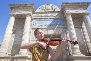 La violinista eslovena Klara Gomboc tocando delante de la puerta del Puente.