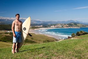 Un surfero delante de la playa de Merón, en el cabo de Oyambre (Cantabria).