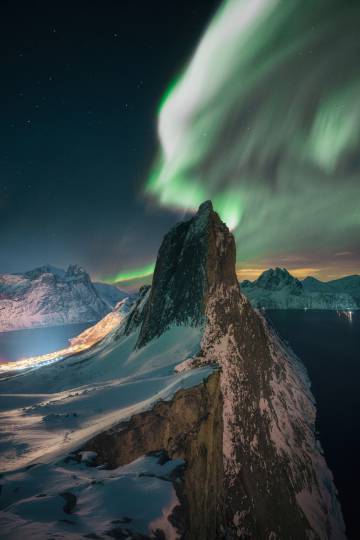 Aurora sobre o topo do pico Segla Senja, ponto culminante das ilhas Lofoten, na Noruega.