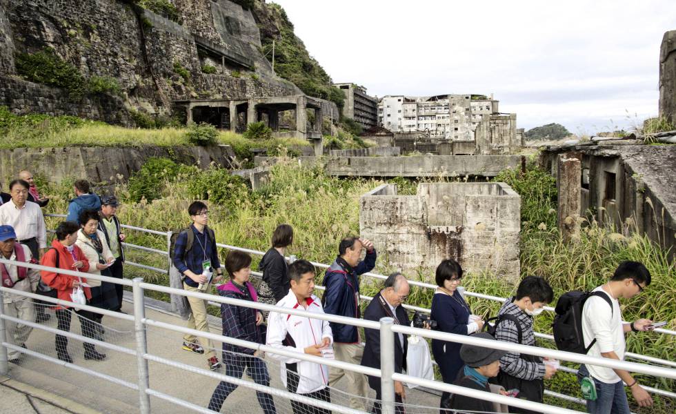 Un grupo de visitantes recorriendo la abandonada isla de Hashima, en Japón.