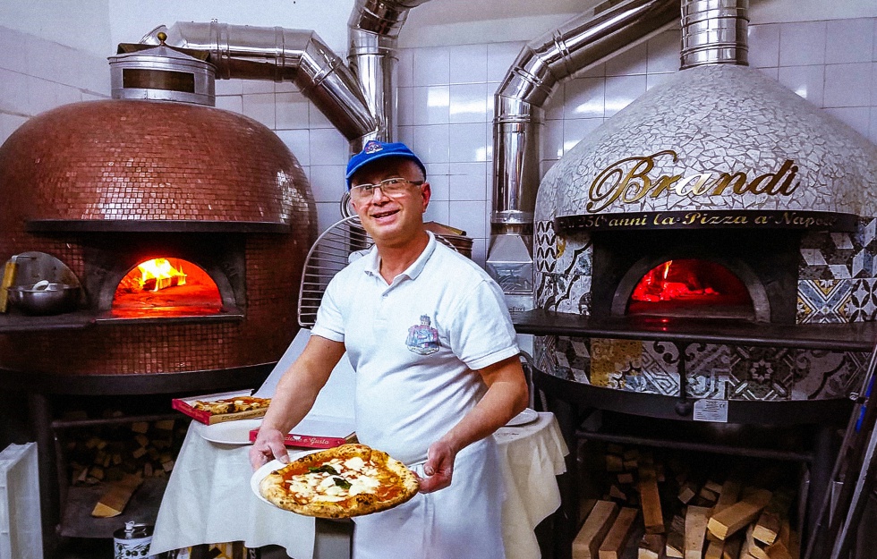 Las cocinas de la Pizzeria Bardi, en Nápoles (Italia), y su 'pizzaiolo' con una margarita.