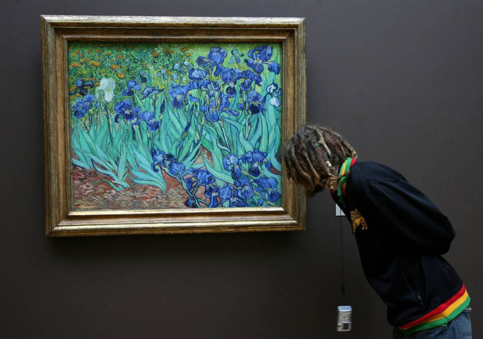 Un hombre contempla de cerca 'Los lirios', de Vincent van Gogh, pintura expuesta en el Getty Center de Los Ángeles.