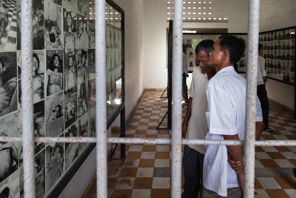 Dos hombres observan fotografías de prisioneros del régimen de los jemeres rojos, en la cárcel de Tuol Sleng en Phnom Penh, Camboya.