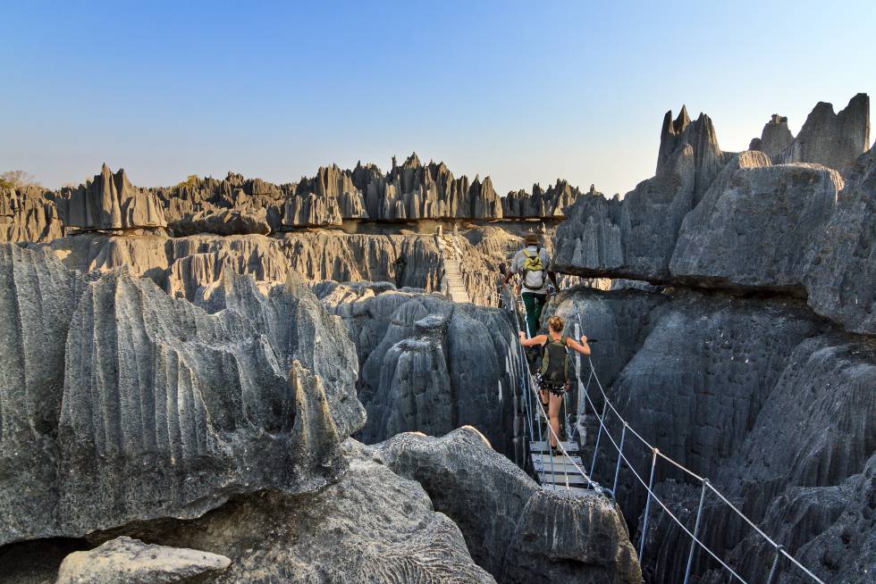 Um casal de turistas atravessa uma ponte suspensa na Reserva Tsingy de Bemaraha, em Madagascar.