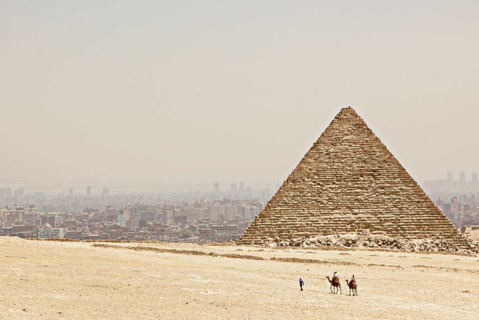 Uma das três pirâmides de Gizé, com a cidade do Cairo ao fundo.