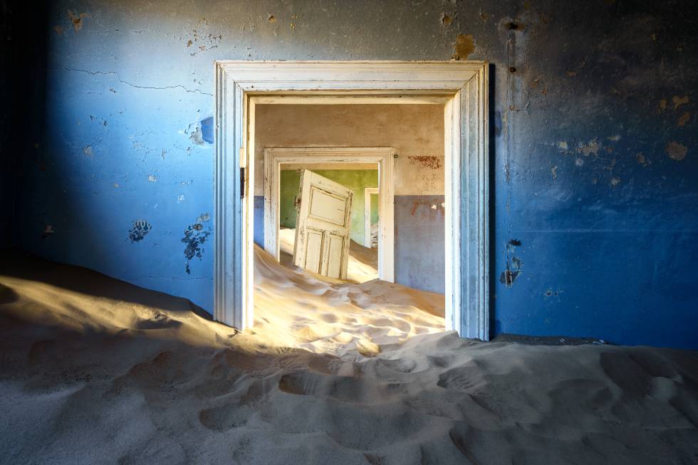 Um edifício na cidade fantasma de Kolmanskop, Namíbia, coberto de areia.