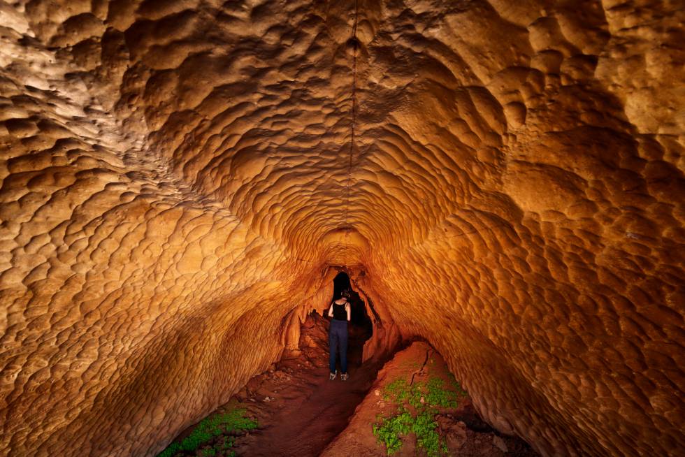 Um turista observa uma caverna nas margens do rio Manambolo.