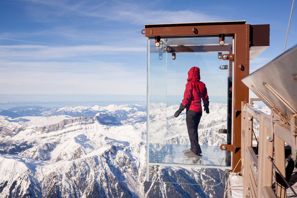 Un turista suspendido sobre la cabina acristalada Pas dans le Vide, en la montaña de Aiguille du Midi, en el Mont Blanc.