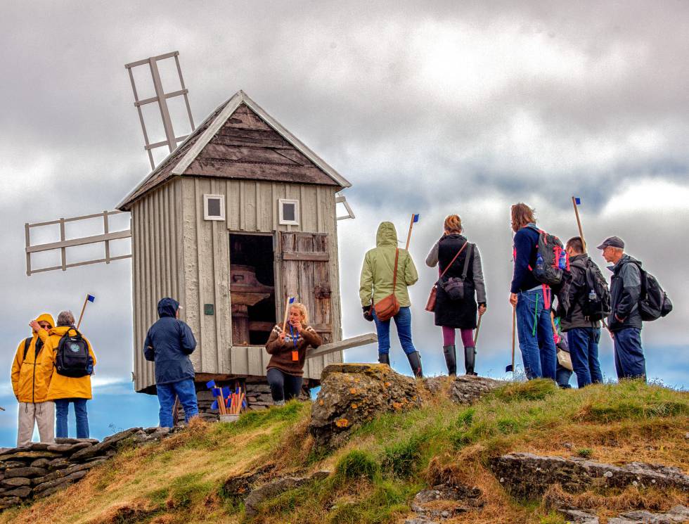 Turistas hacen fotos junto al molino de viento más antiguo de Islandia. Data de 1840 y ejerce de faro en la isla de Vigur, en la región de los Westfjords.