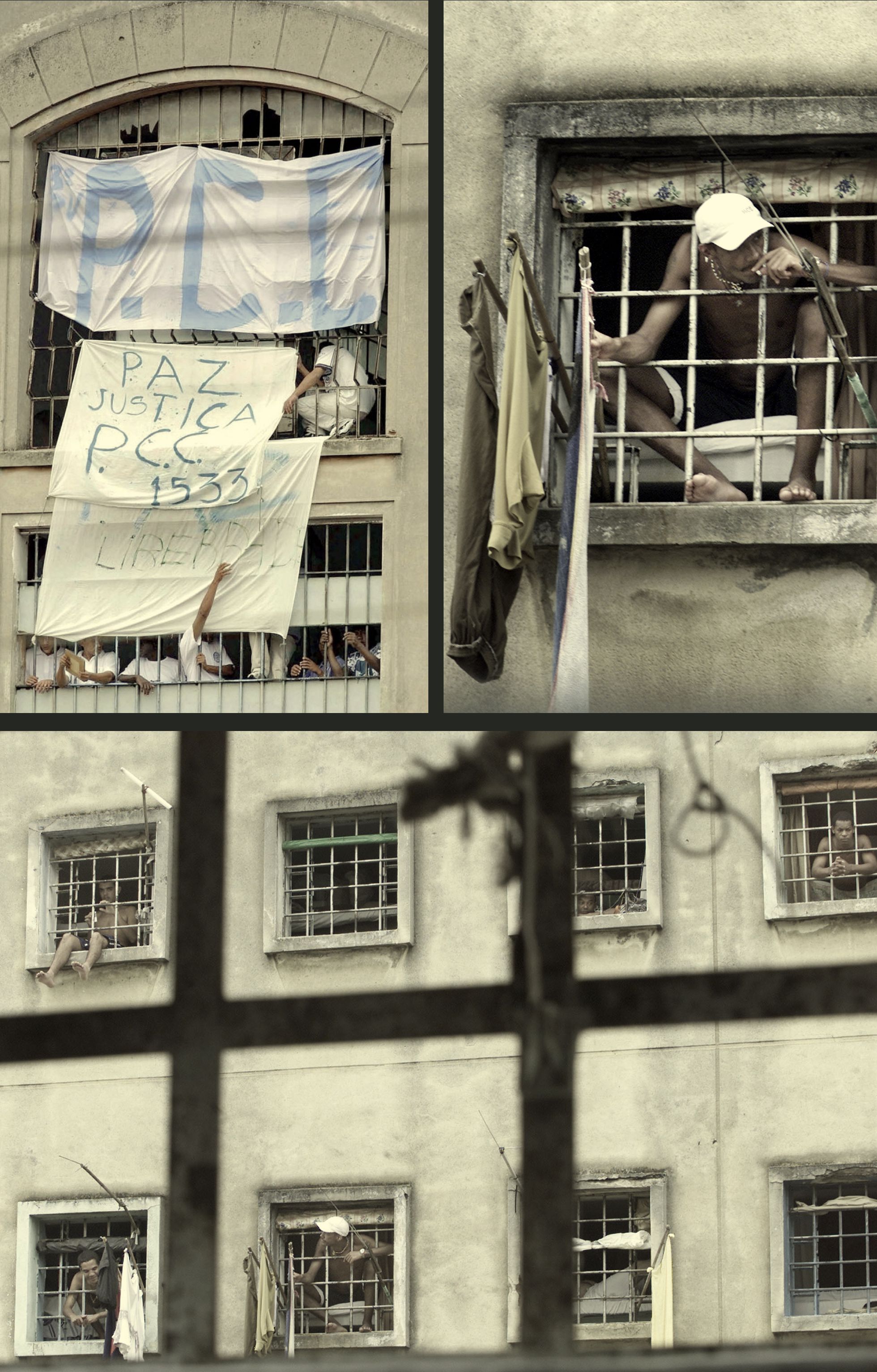 Detentos mostram lemas e a siglas do PCC das janelas da prisão do Carandiru, em São Paulo, na primeira grande ação do grupo, um motim simultâneo em penitenciárias de 30 municípios, no começo de 2001. / AFP