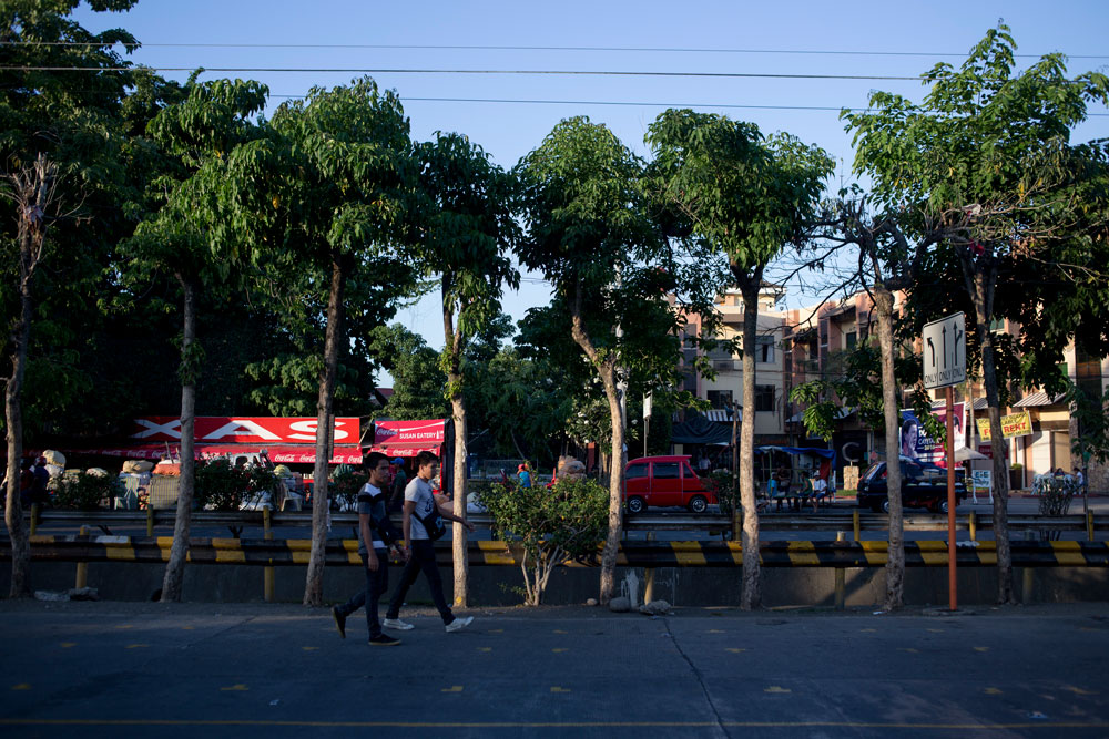 Dos jóvenes caminan por Roxas Avenue, una de las arterias principales de Davao