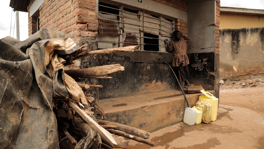 Casa y niño con garrafas de agua