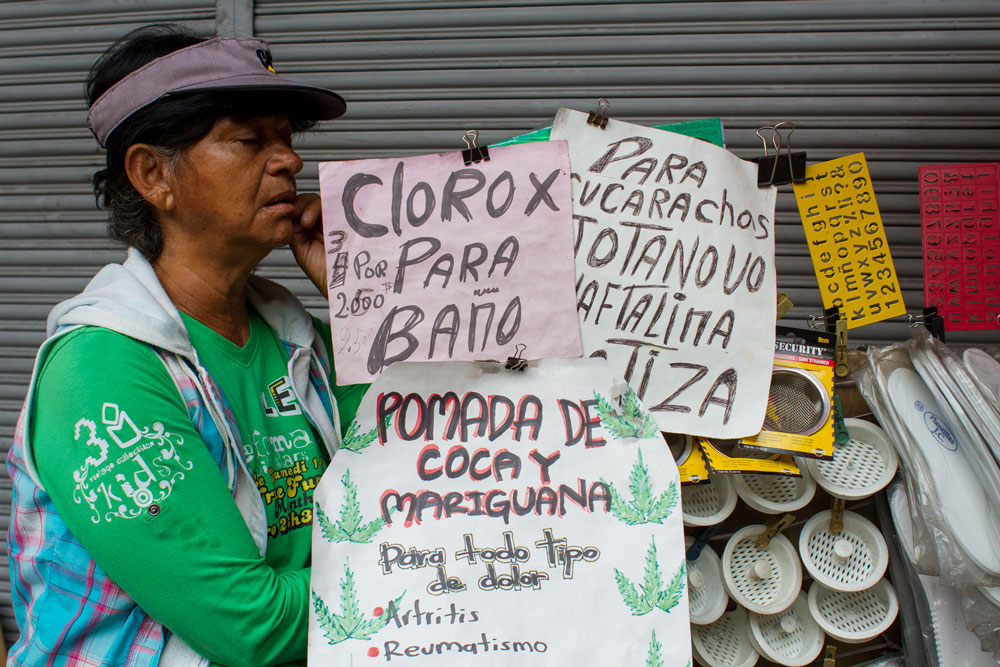 Una señora vende diversos productos en un carrito en la calle