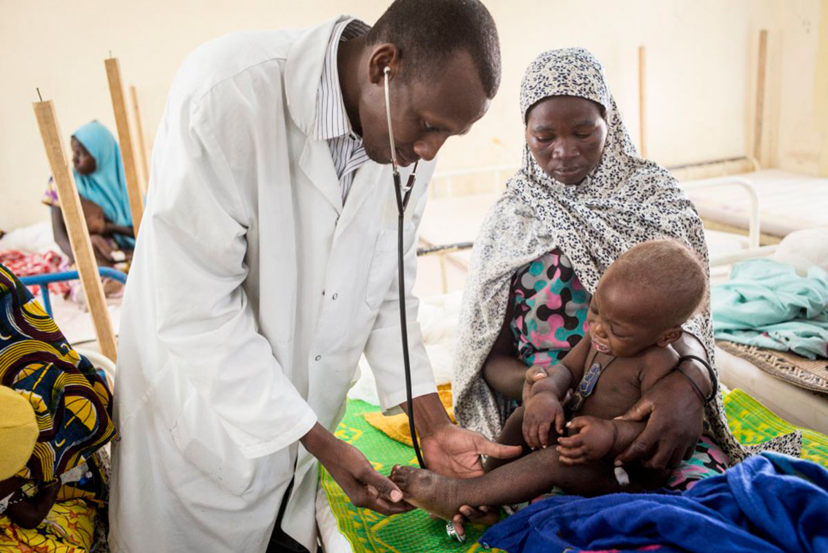 El doctor Adamou Abass, de 33 años, ausculta a la pequeña Cahmsidine, de 18 meses, ante los ojos atentos de su madre, Amdame Oumarou