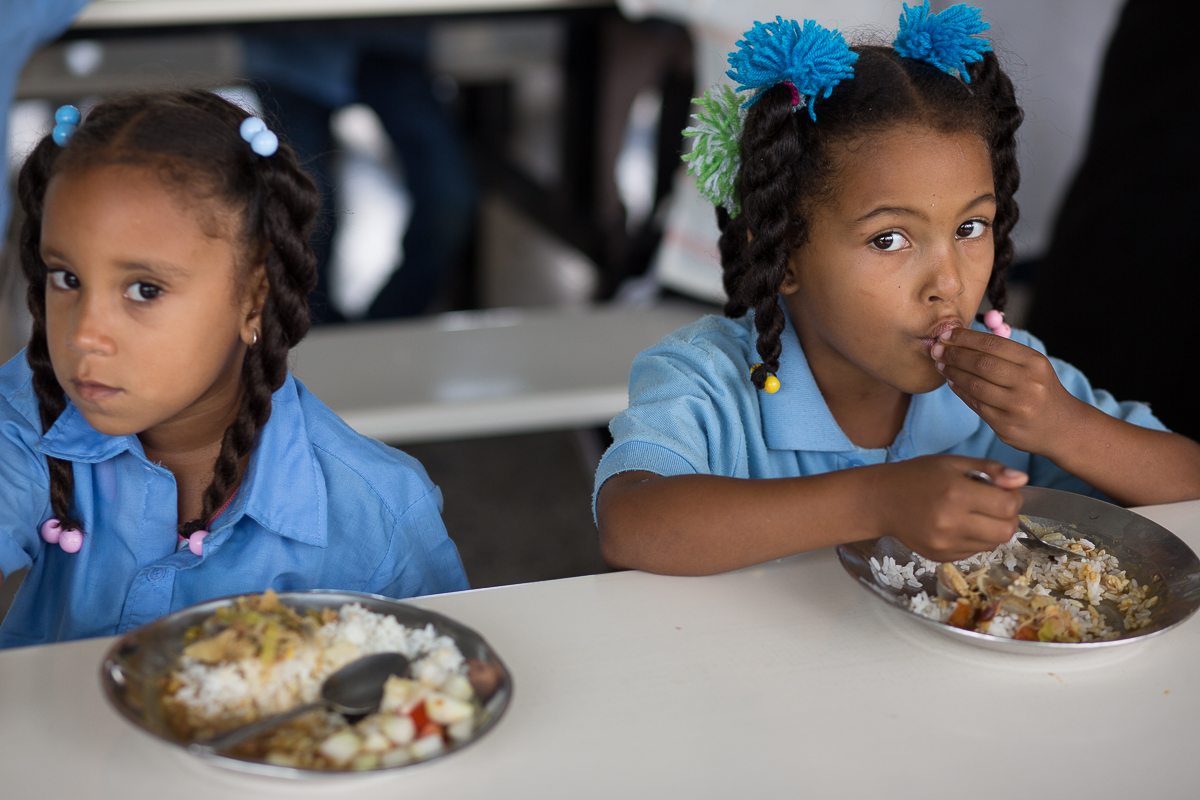 Dos niñas dan cuenta del almuerzo escolar