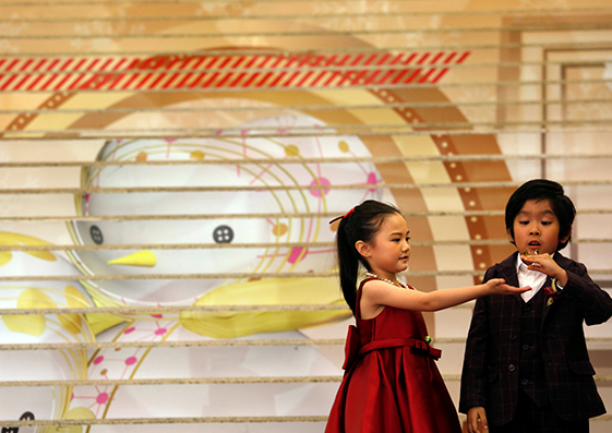 Dos menores juegan en las escaleras que llevan al centro comercial Harbour City durante una ceremonia de encendido de luces de Navidad en Hong Kong, China, el 10 de noviembre de 2016.