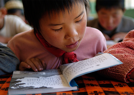 Una niña lee un libro de texto en la escuela primaria del pueblo de Heping, China.