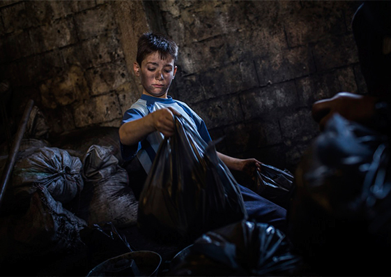 Talal Louai, de Homs, Siria, mete carbón en bolsas de dos kilos en un pueblo de Líbano, en enero de 2014. “Echo de menos el colegio, especialmente las ciencias. Quiero ser cirujano”, dice.
