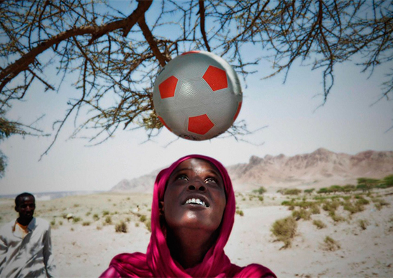 Maymun, madre y refugiada, muestra su habilidad para jugar al fútbol en un campo de Yibuti en marzo de 2012.