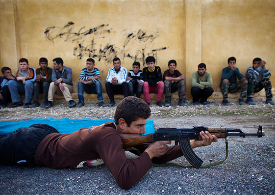 Sobhi, un joven sirio de 15 años, sostiene un rifle de asalto AK-47 mientras recibe entrenamiento en enero de 2013 en una antigua escuela convertida en academia militar en Tlaleen, Siria.
