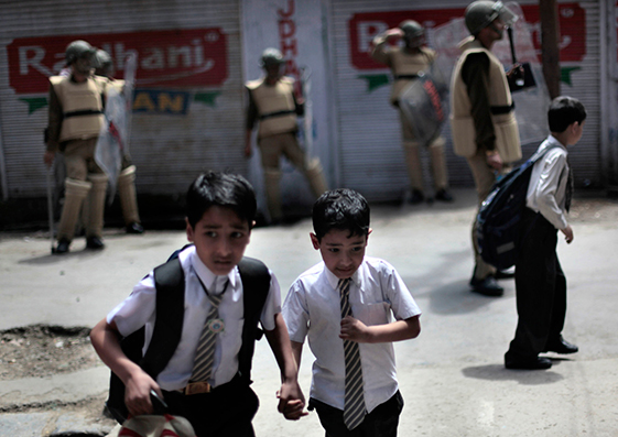 Escolares corren para protegerse durante una manifestación en Srinagar, Estado de Cachemira, India, el 28 de abril de 2011.