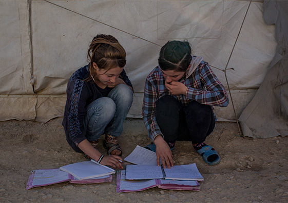 Dos niñas hacen los deberes en un campo para desplazados yazidíes en noviembre de 2016, en  Sharya, Irak.  Los yazidíes son una minoría religiosa perseguida por el Estado Islámico.