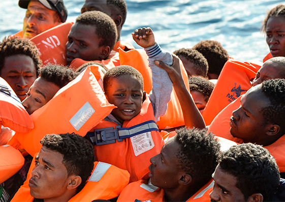 Un niño sentado entre inmigrantes en un bote hinchable frente a las costas libias  esperando a ser rescatados el 4 de noviembre de 2016.
