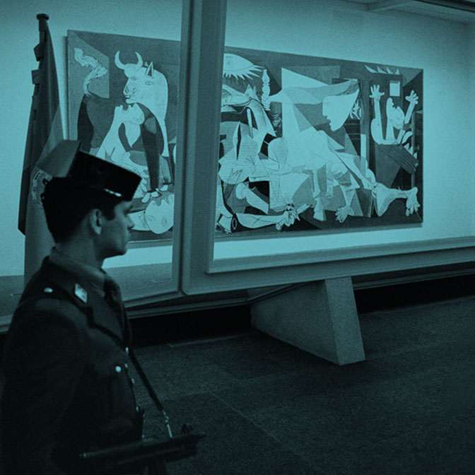 Guardia Civil en primer plano y Guernica al fondo