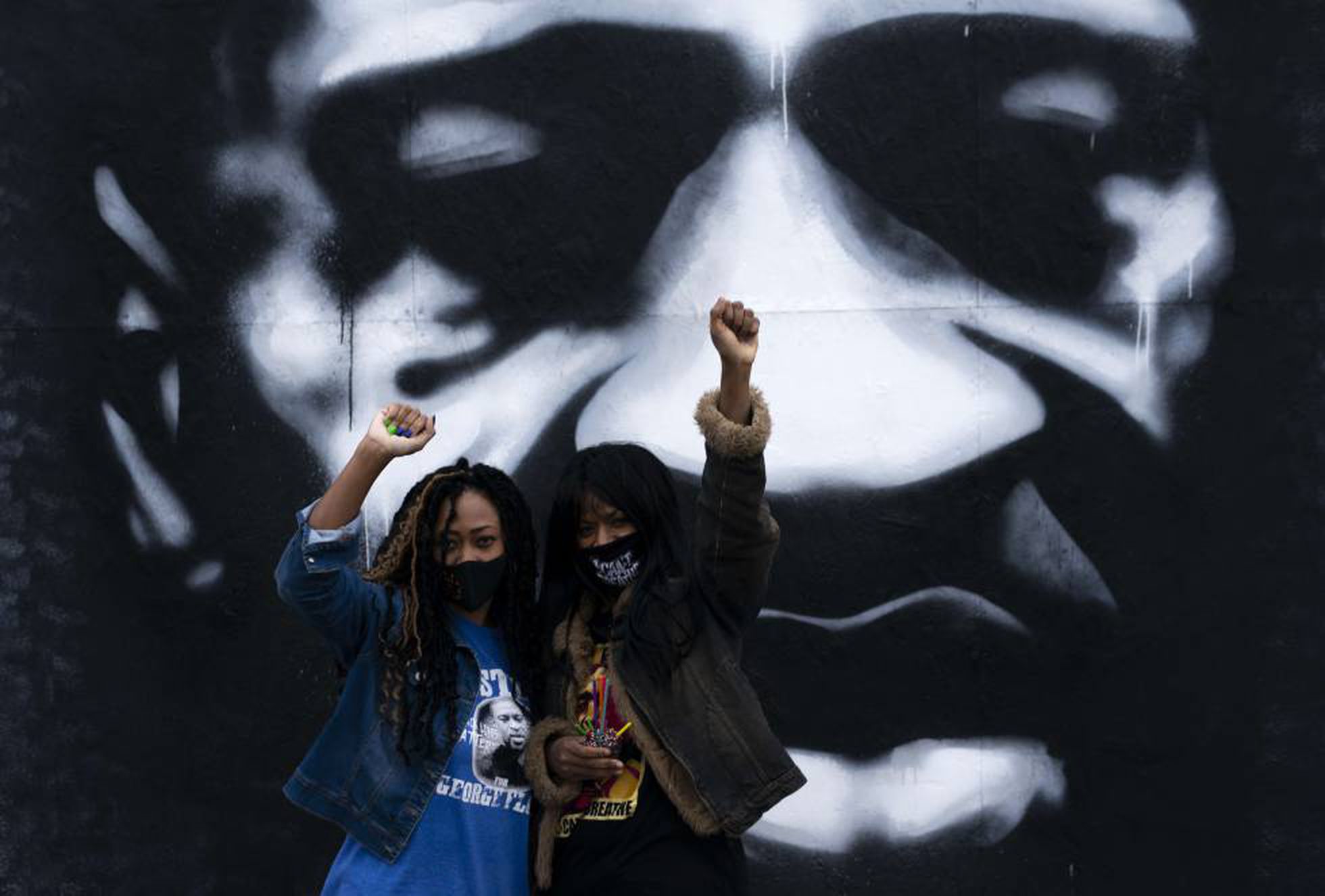 Dos mujeres negras levantan el puño ante un mural de George Floyd en Minneapolis, el pasado octubre.