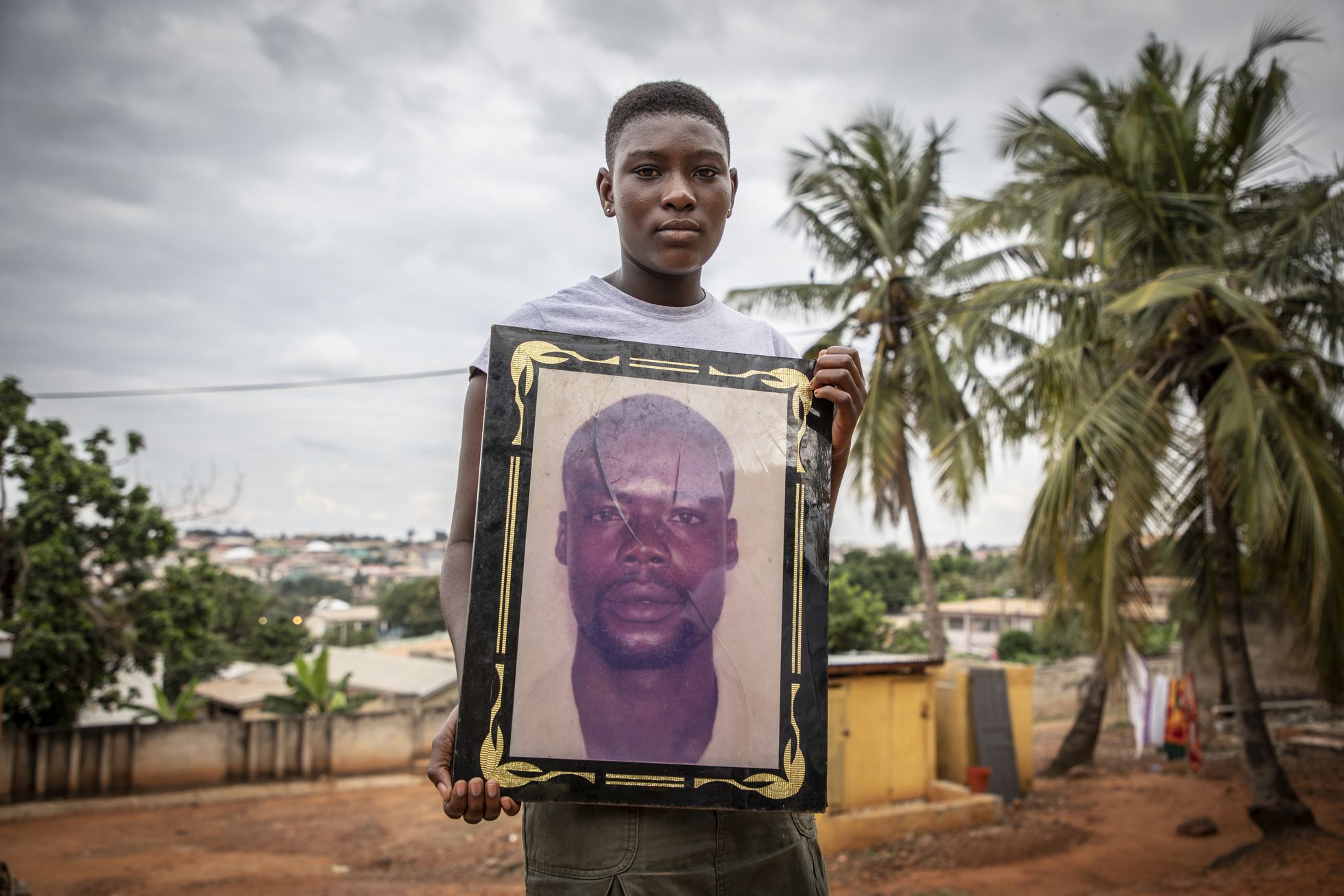 En 2005, medio centenar de emigrantes que trataba de viajar a Europa, en su mayoría ghaneses, desembarcó en una playa de Gambia. Yahya Jammeh los ejecutó con especial crueldad. En la imagen, Sarah Boadu, de 15 años, sostiene una fotografía de su padre Richmond, uno de los emigrantes asesinados, en Kumasi (Ghana). 