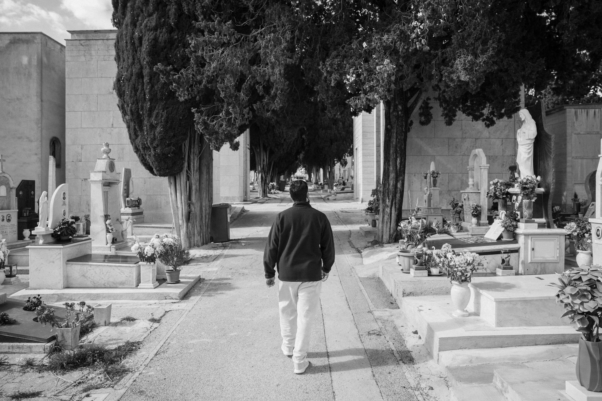Giuseppe Cimarosa pasea hacia la tumba de su padre en el cementerio de Castelvetrano.