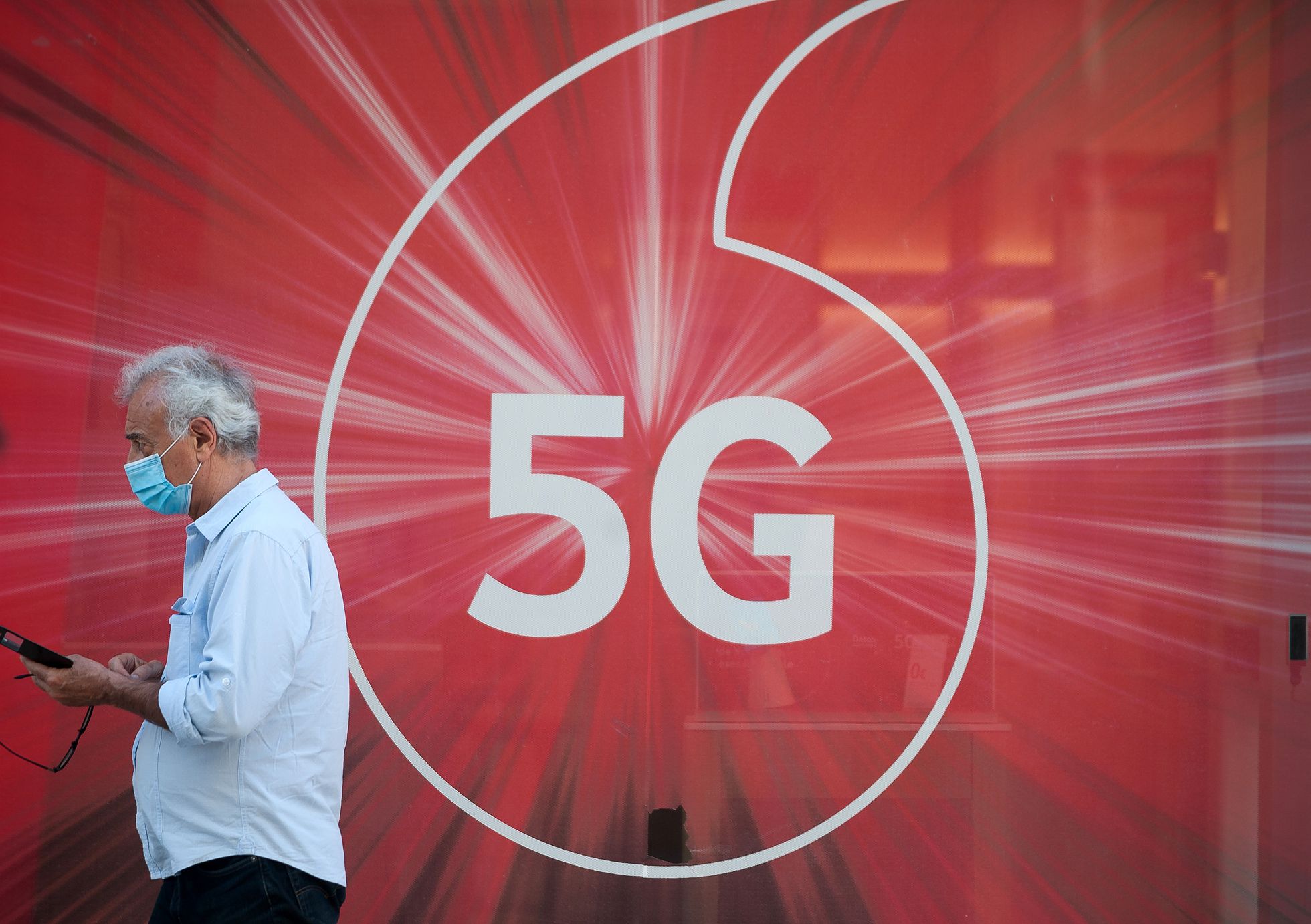 Un hombre camina ante un anuncio de la tecnología 5G en Málaga. 