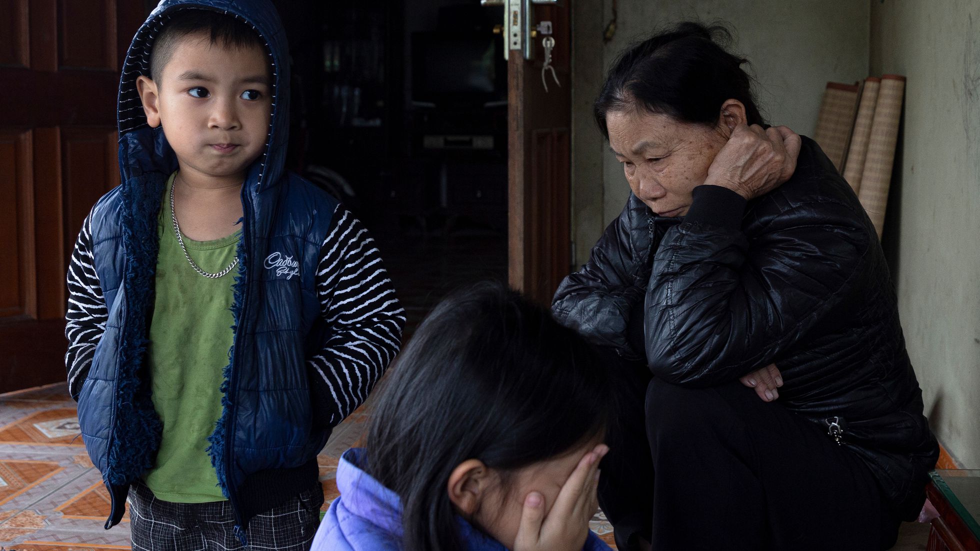 Pham Thi Ha, madre de Bui Thai Thang, otra víctima, con dos de sus nietos, hijos del fallecido.