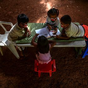 Unos niños indígenas emberá consultan un libro mientras dan clase en su comunidad en marzo de 2021 en Puru Embera, provincia de Colon, Panamá. En tiempos de pandemia y sin conexión a internet, estudiantes como estos reciben lecciones gracias a profesores que se desplazan a sus comunidades.
