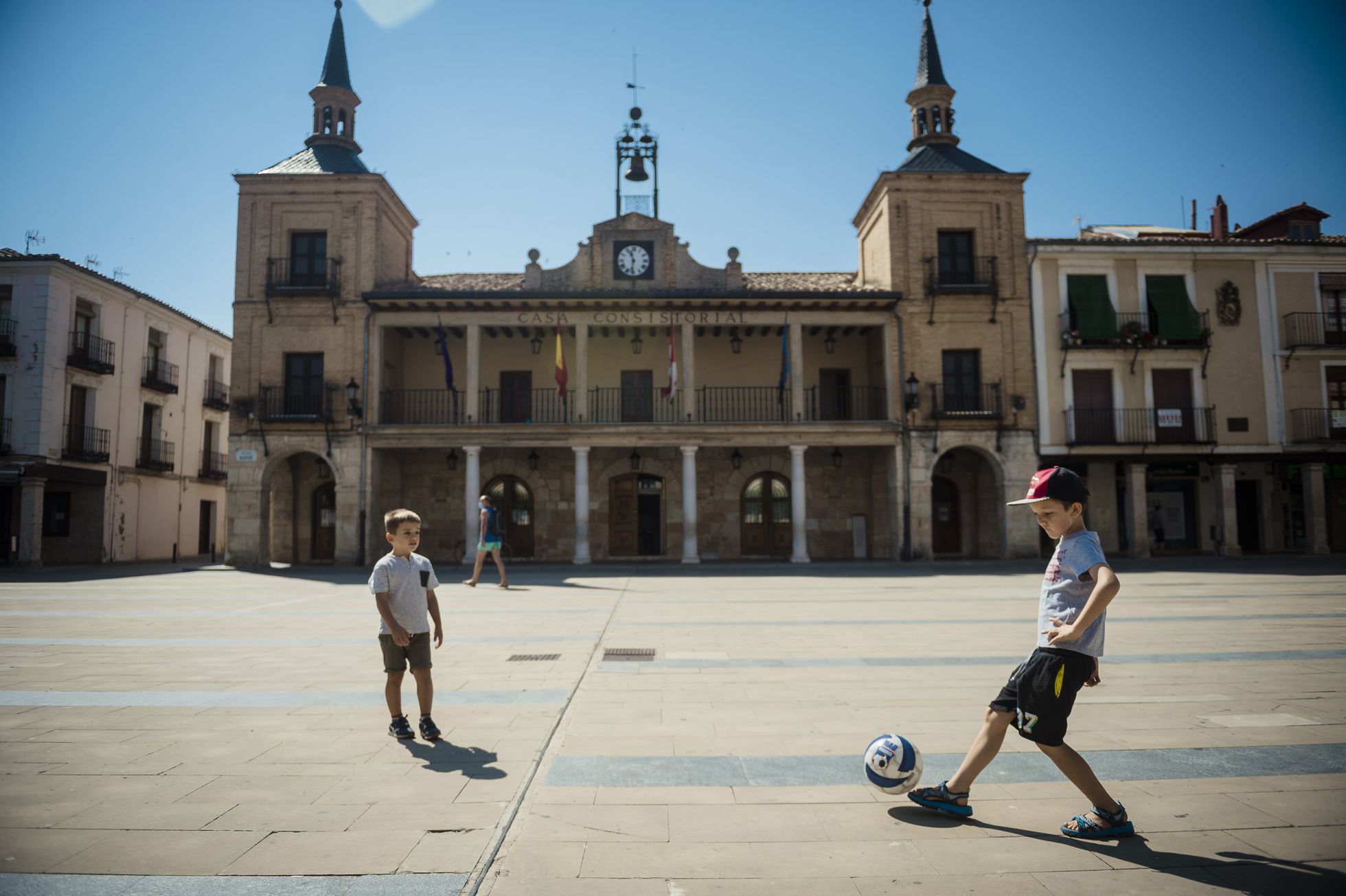 Dos niños juegan al fútbol en la plaza mayor de Burgo de Osma (Soria).