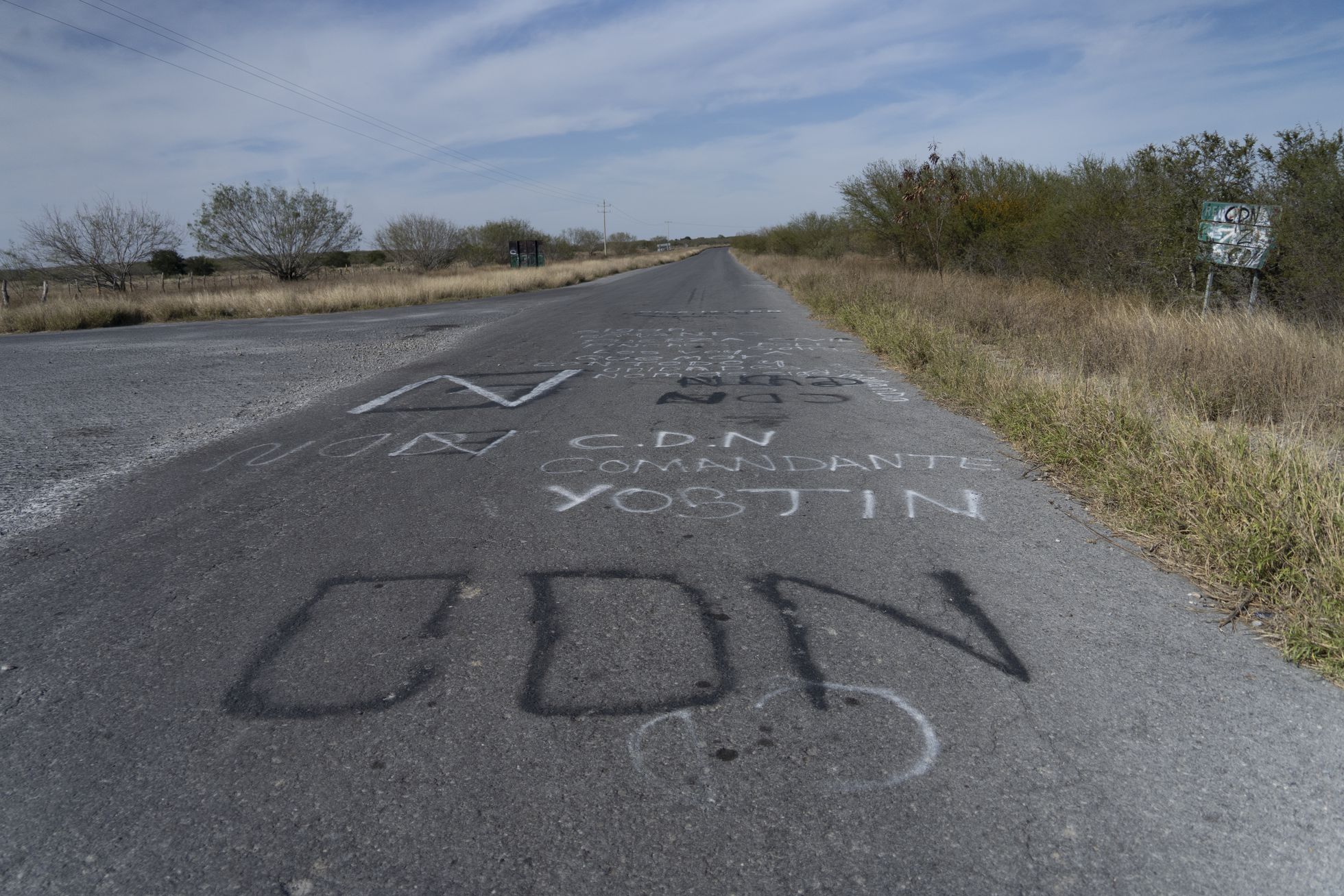 Mensajes del cartel del Noroeste sobre el asfalto del camino que conduce al ejido de Santa Anita, en la frontera de los Estados de Nuevo León y Tamaulipas.