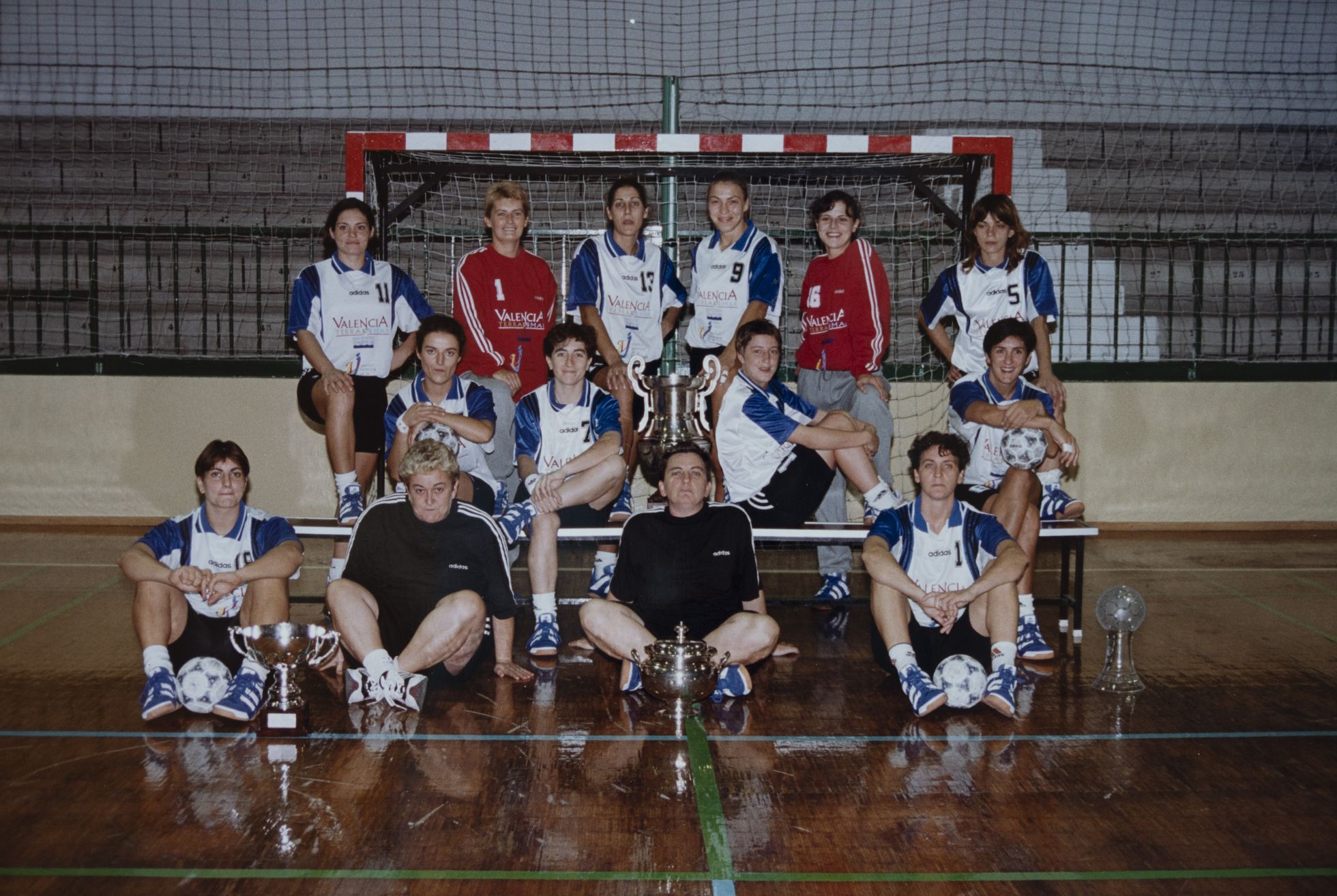 Foto del equipo que lo ganó todo en 1997. Las jugadoras y cuerpo técnico del Osito posan con las copas de la Liga, la Copa de la Reina, la Copa de Europa y la Supercopa de Europa.
