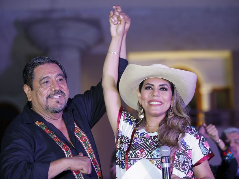 Félix Salgado Macedonio sostiene la mano de su hija Evelyn Salgado de manera triunfal, tras los primeros resultados de las elecciones en Guerrero.