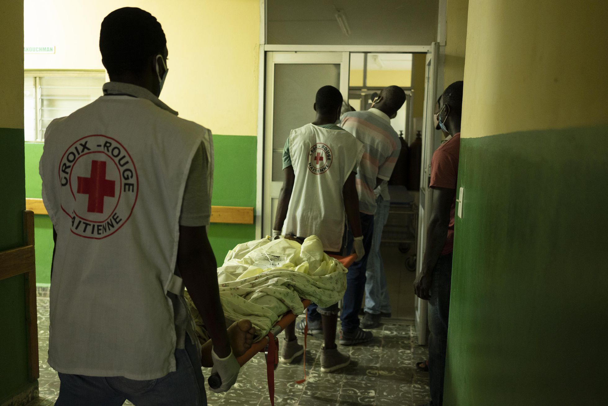 Voluntarios de la Cruz Roja llegan al hospital Port Salut con un herido por el terremoto. 