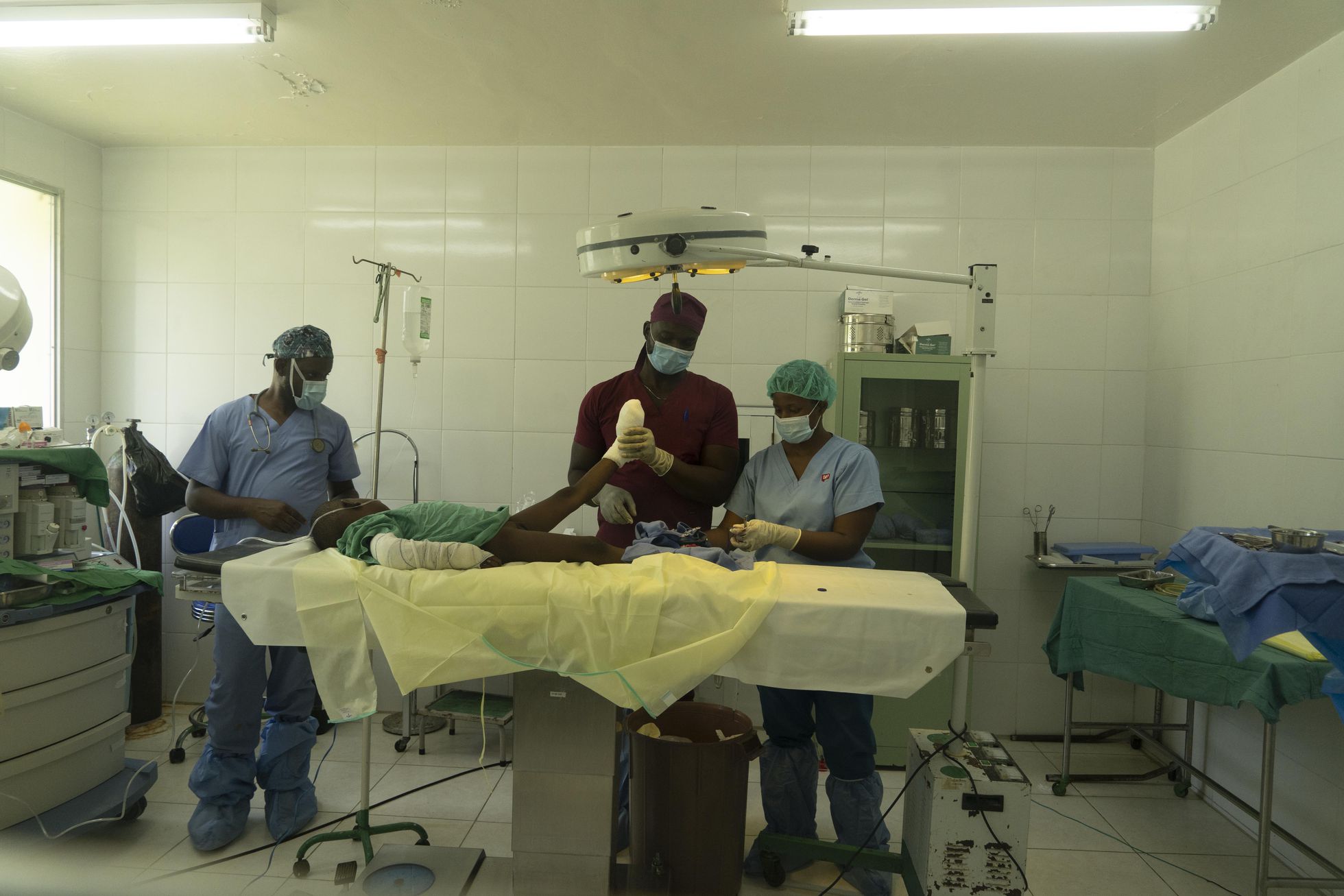 Los medicos Reginald Maluvision y Chovel Alcy amputan un dedo del pie al pequeño Samson Stephen, en el hospital de Port Salut.