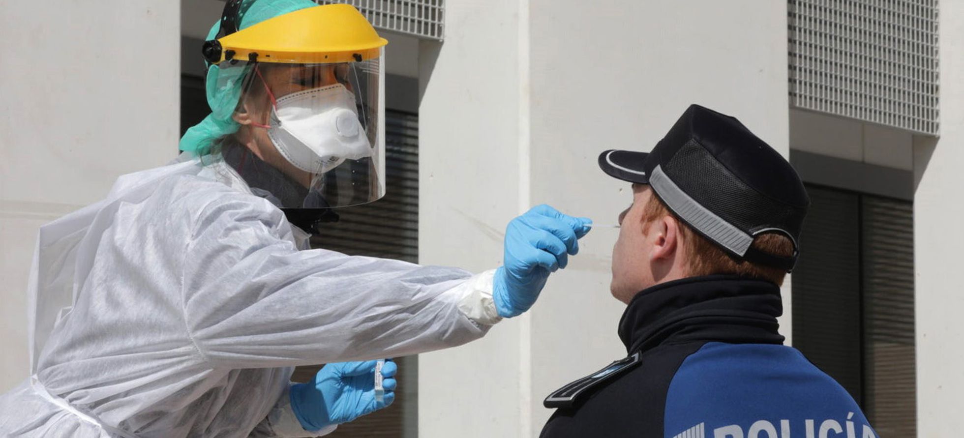 Una sanitaria realiza una prueba PCR a un policía local en Madrid para detectar el coronavirus.